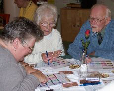 Elderly people filling in the awards cards