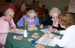 Elderly people filling in the awards cards